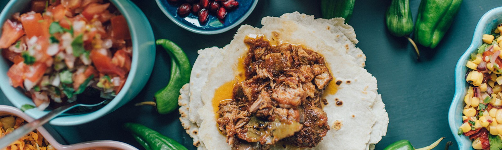 Tacos and corn salsa and pico de gallo on a wooden table Tacos and corn salsa and pico de gallo on a wooden table