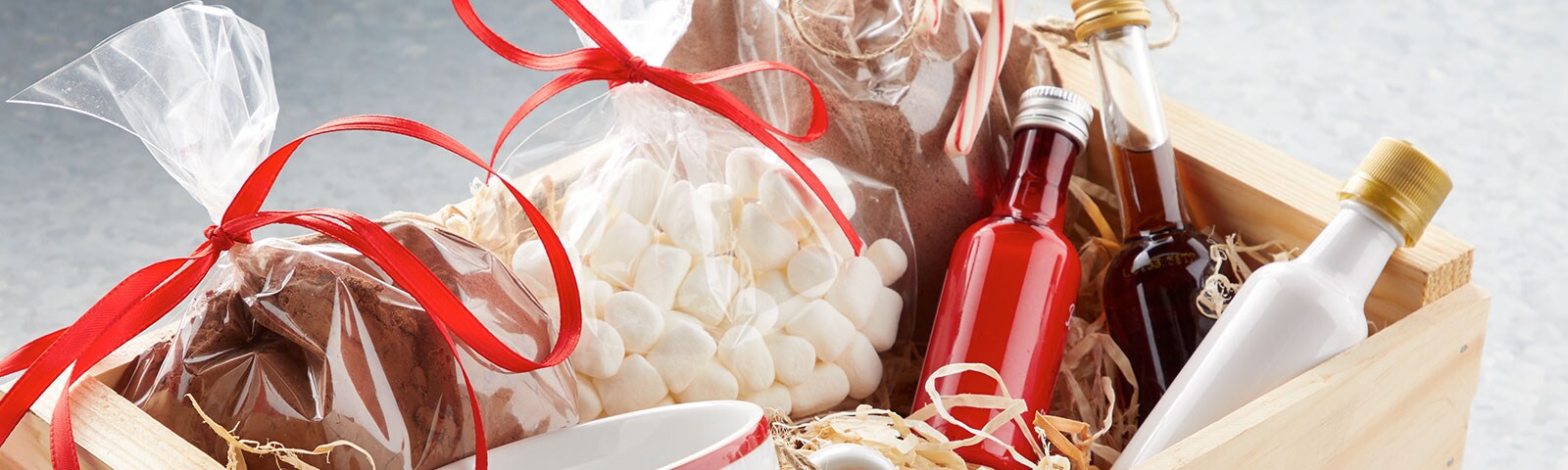 Wooden box filled with colorful mini liquor bottles, cocoa powder, and mini marshmallows Wooden box filled with colorful mini liquor bottles, cocoa powder, and mini marshmallows