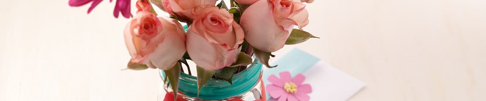 Decorated mason jar filled with pale pink roses